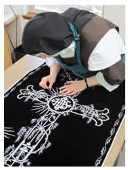 Sister places sets of rays for around the embroidered Weeping Willow Cross black vestment applique