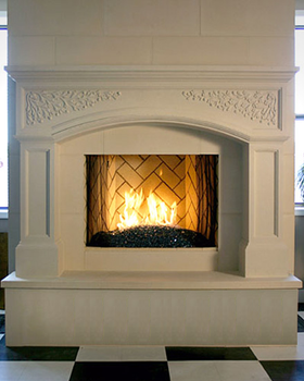 Classic arch design in the header of the stone mantel installed on a raised hearth with extra facing to clad the hearth