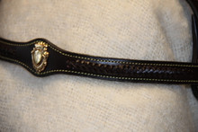 Browband feature showing single leather scallop with Brass Medallion in centre. Plaited leather rope either side of medallion.
