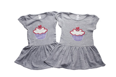 Our twin Cutest Little Cupcake on the sweetest heather grey dress. 2 sweet to have just 1 that's why are made for twins. Can you find our signature number 2's in this design?