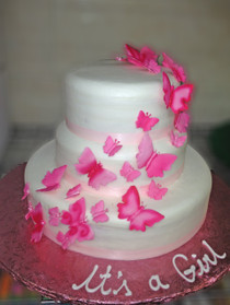 Approximate Servings 80. Sizes: 7", 10" & 14". Three tiered cake with ribbon wrapping around and cascading sugar butterflies.