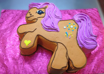 Approximate Servings 50. Size: Custom. Cake is cut out in the shap of a Cartoon Pony.