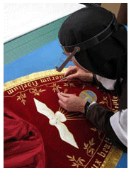 Sister pulling in stray threads on the cope hood sister sewing red cope