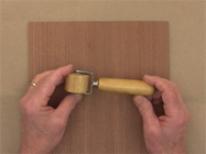Apply pressure to the veneered surface using a one inch wallpaper seam roller