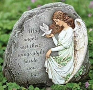 Stone with an angel drawing and inscription that says “May angels rest their wings right beside your door.”