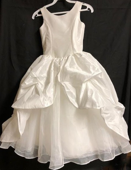 This dress is made with high-quality materials, including organza, French net, and bridal satin. If you are looking for a simple, yet stunning First Holy Communion dress for your daughter, this is a great option. The simple style paired with the beautiful detailing creates a dress that your little one will absolutely love. Start shopping for your daughter or granddaughter’s communion dress now. 
Please call us at 1.800.523.7604 for verification of items in stock as they are selling quickly!  Items are non returnable!