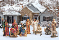 Metal Nativity set with the Holy family, three kings, angel, two shepherds, and animals displayed in a yard.