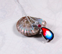 Ammolite pendant.Tricolour in silver with ruby companion.