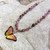 #16. Coral Butterfly Necklace: $75
 gold / dark rim/gold overlay chain
Niobium
• Swarovski crystal
• Bohemian glass
• Gold overlay chain
• Adjustable: 18-20" long
• Drop: 3/4" l. x 1" w.
