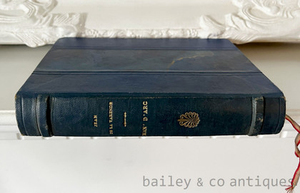 Discover a rare 1947 deluxe numbered edition of Jean de La Varende's Man' d'Arc. Custom bound in Prussian blue half-leather with spectacular gold-veined marbled boards, original paper wrappers and spine conserved, and color plates by Derambure. An exceptional decorative statement book.
