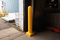 Yellow 6" x 48" Plated Bollard Cover protecting overhead door tracks