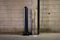 Black 6" x 48" Plated Bollard Cover protecting a storage area