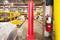 Red 6" x 48" Plated Bollard Cover protecting facility columns and marking fire extinguisher location