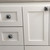 Tiki Square knobs light sapphire and moonstone with shaker style cabinet drawers in creamy white.