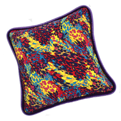 Cabo Pillow covered in splashy colorful printed silk and trimmed with velvet piping
