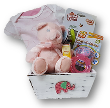 Celebrate the new arrival of a baby girl with this assortment of items:  onsie, rattle, soother, teether, diaper cream and plush bear.