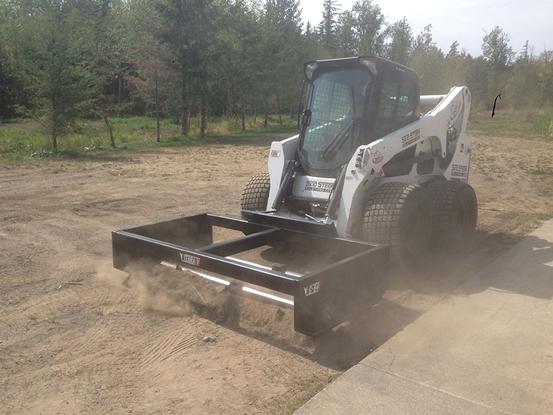 One Gravel Road, One Machine and One Box Grader Attachment Skid Steer