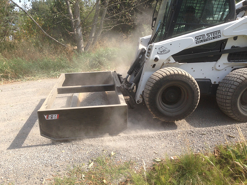 One Gravel Road, One Machine and One Box Grader Attachment Skid Steer