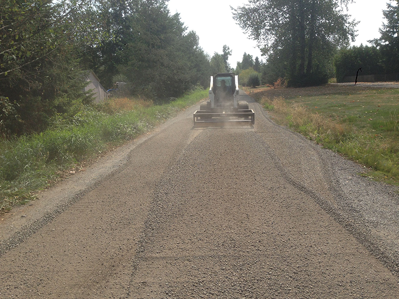 One Gravel Road, One Machine and One Box Grader Attachment Skid Steer