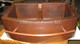 Copper Farmhouse Sink Double Well 33x22x10 Rounded Front 8" Divider with towel bar somber patina close up view