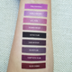 purple, lavender, and dark liquid lipstick swatches on light skin