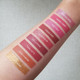 Aromi liquid lipsticks swatched on light skin