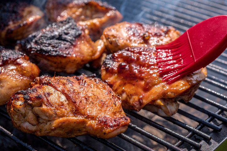 silicone brush coating chicken in marinade on grill