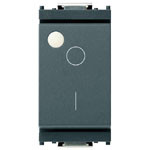 Grey 1-way switch with white small round light at top corner. Has a circle and dash on the front on a white background