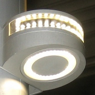 A silver half circle on a pole. A circular white light on the bottom. A row of lights at the top from side to side. Dark background