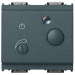 A wide dark grey switch. 2 small round knobs on the front. A small light on top center. On a white background