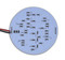 A grey circle Emma-36SMD-5050 WW. Small black dots. red and black wire coming out of it. On a white background