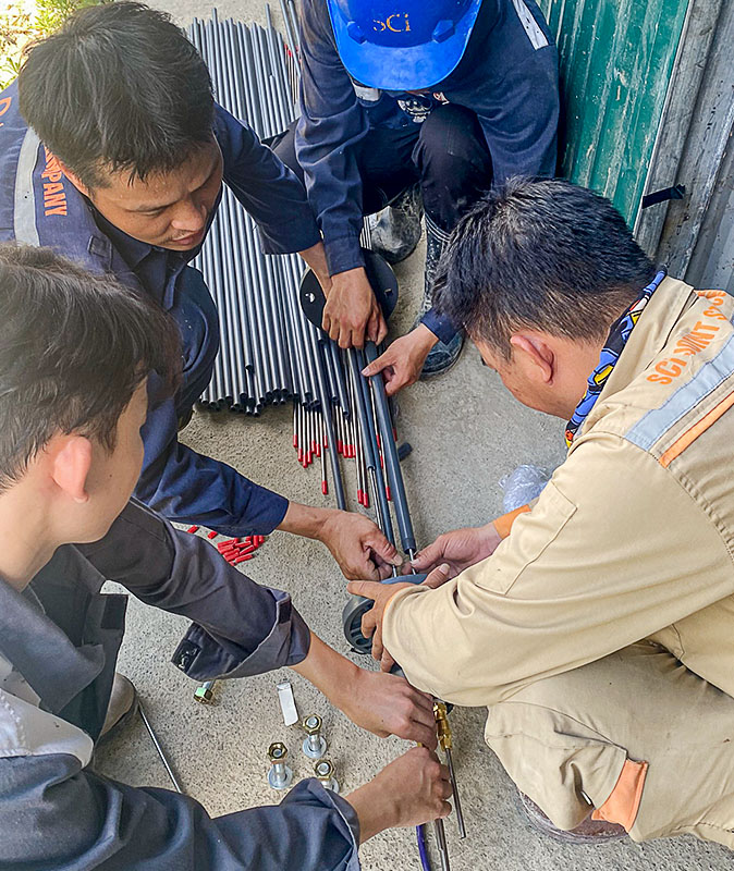 Photo of workers installing the Model 1100 Rod Type Borehole Extensometer at the Nam Sam 3 Hydropower Plant.