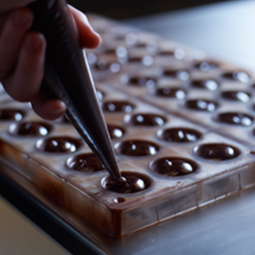 Image of worker filling chocolate mold
