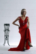 In this full body view, wearing a shoulder length blond wig and a long, red formal dress, mannequin Emily sits with her right leg crossed over her left and her left hand resting on her right knee. Her right hand is at her waist.   With pierced ears, mannequin Emily can display earrings and jewelry.  Pedestal included.