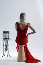In this full body rear view, wearing a shoulder length blond wig and a long, red formal dress, mannequin Emily sits with her right leg crossed over her left and her left hand resting on her right knee. Her right hand is at her waist.   With pierced ears, mannequin Emily can display earrings and jewelry.  Pedestal included.