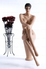 In this full body view, naked mannequin Ruby sits with her right leg crossed over her left and her right hand resting on her right knee. Her left hand rests on her left knee.   With pierced ears, mannequin Ruby can display earrings and jewelry.  Pedestal included.