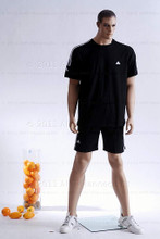 In this full body view photo, wearing a black shorts with a short-sleeved athletic jersey, mannequin Matt stands with his legs apart in an even stance, with both hands almost straight down at hip level.  Mannequin Matt can be displayed with or without a wig / hairpiece.  Glass stand and support hardware included.