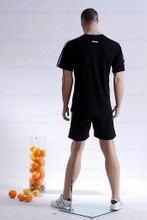 In this full body rear view photo, wearing a black shorts with a short-sleeved athletic jersey, mannequin Matt stands with his legs apart in an even stance, with both hands almost straight down at hip level.  Mannequin Matt can be displayed with or without a wig / hairpiece.  Glass stand and support hardware included.