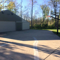 LED Shoebox light fixtures mounted on a poll shed to light up a basketball hoop court.