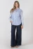 Full-length portrait of model wearing Black Tape neutral button front shirt styled with denim