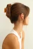 Lifestyle view of a woman organizing items while wearing the Kōv Essentials daily clip in honey