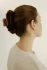 Full-length portrait of a woman wearing the Kōv Essentials medium daily clip in cider in her hair against a plain background