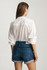 Close-up detail view of the mid brushed classic blue denim texture, folded cuff hem, and back pockets
