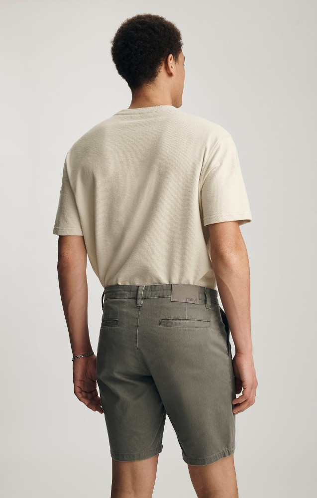 Back view of Mavi Noah olive vintage colored shorts showing back welt pockets and waist fit