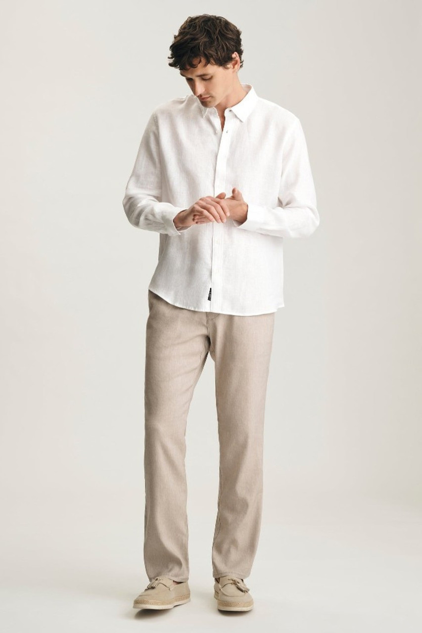 Full-length portrait of model wearing white Mavi linen button-down shirt styled casually with denim