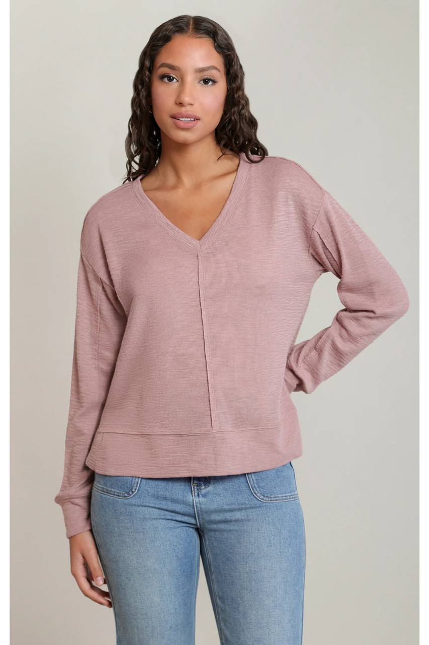 Front view of model wearing Dex V-neck knit sweater top in dusty rose with blue jeans