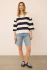 Full-length portrait of model wearing navy stripe Gentle Fawn Amina top styled with denim