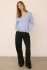 Full-length portrait of model wearing heather blue Gentle Fawn Carina pullover styled with denim