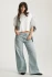 Full-length portrait of model wearing white Mavi Riley crew neck t-shirt styled with wide-leg jeans