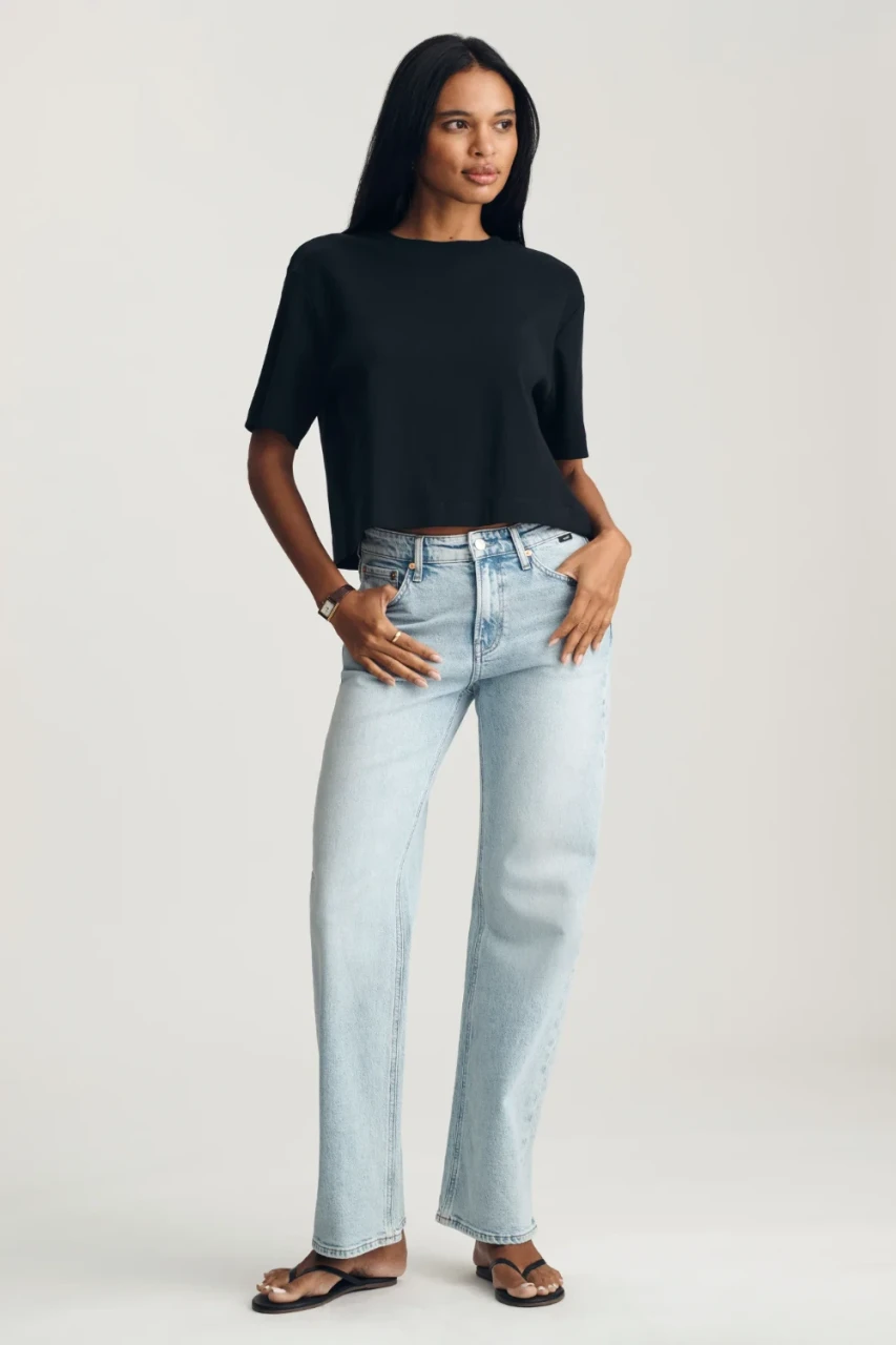 Full-length portrait of model wearing black Mavi Riley crew neck t-shirt styled with denim